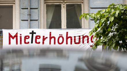 Ein Banner mit der Aufschrift Mieterhoehung hängt an einem Balkon einer Mietwohnung in Berlin.