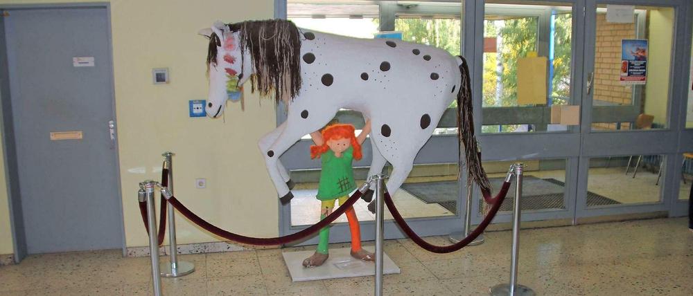 Im Foyer der Schule stemmt Pippi Langstrumpf ihr Pferd "Kleiner Onkel"