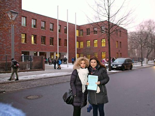 Nebi Sabani (links) und Sibel Demir mit den Unterschriftenlisten vor dem Schulgebäude.