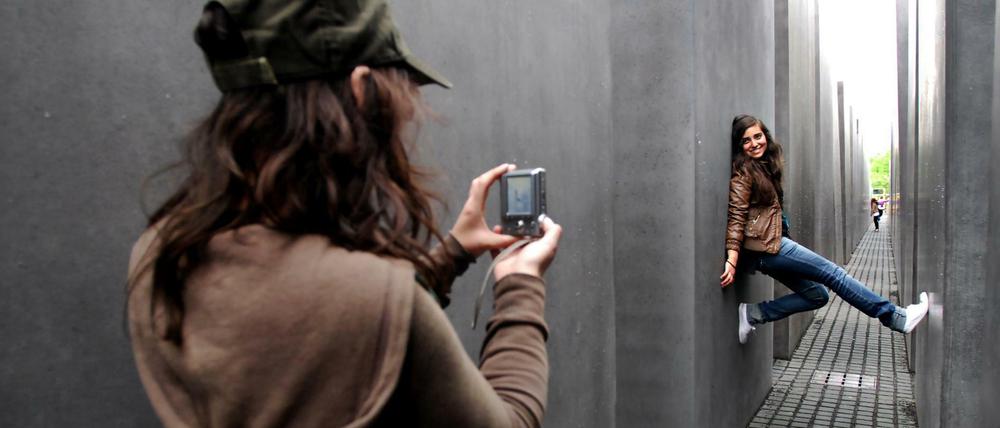 Touristen machen Erinnerungsfotos zwischen den Betonquadern des Holocaust-Mahnmals.