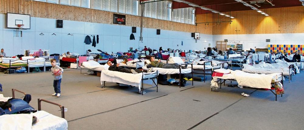 Vorübergehende Heimat. In Turnhallen leben Flüchtlinge oft wochenlang. Ohne materielle Folgen bleibt das nicht. Hier die Sporthalle der Freien Universität (FU) in Dahlem. 