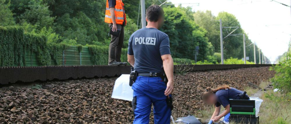 Mitarbeiter der Bahn und der Kriminalpolizei untersuchen am 19.07.2017 am Gleisbett einen Kabelschacht an der Bahnstrecke in der Nähe von Groß Behnitz bei Berlin.