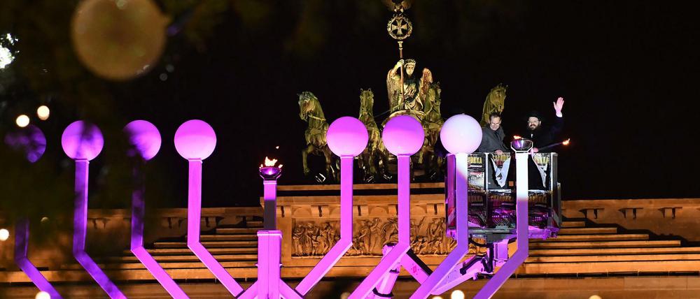 Licht im Dunkeln. Rabbiner Yehuda Teichtal (r) und Michael Müller zünden die erste Kerze am Chanukka-Leuchter vor dem Brandenburger Tor an. 