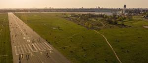 Menschen sind während des Sonnenuntergangs auf dem Tempelhofer Feld unterwegs. Seit einigen Monaten hat die Debatte um eine Randbebauung wieder an Fahrt aufgenommen.