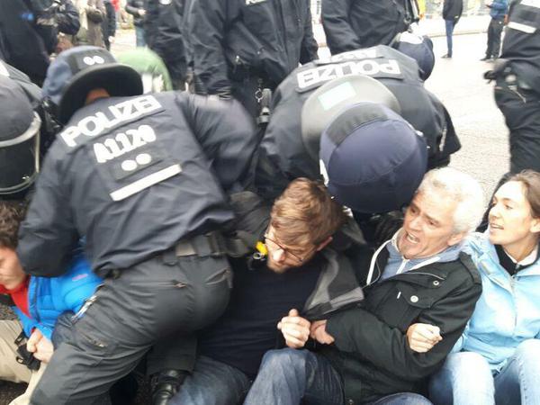 Die Polizei löst eine Sitzblockade auf der Karl-Liebknecht-Straße auf.