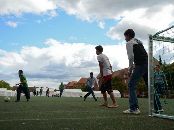 Junge Flüchtlinge spielen in der Schmidt-Knobelsdorf-Kaserne in Berlin-Spandau Fußball. 