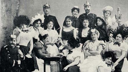 Eine bunt kostümierte Gesellschaft von Dienstbotinnen, Köchinnen und Gendarmen stellen das Komitee des Gesindeballs im Jahr 1898 in Berlin.