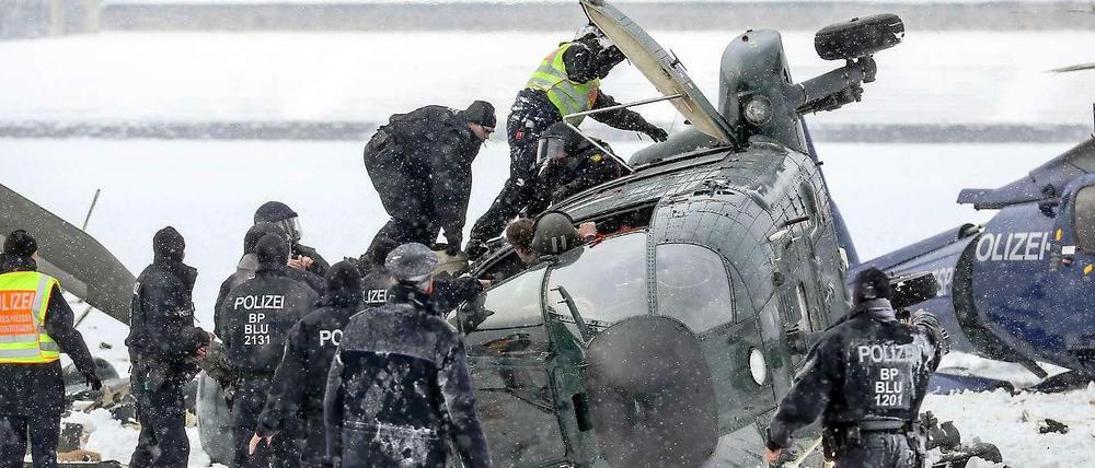 Crash im Schneetreiben. Retter bergen am 21. März 2013 die Passagiere und den getöteten Piloten aus dem Wrack. Der Hubschrauber der Bundespolizei war bei der Landung auf dem Maifeld am Olympiastadion abgestürzt.