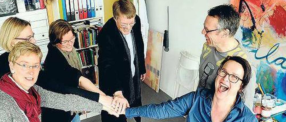 Zusammenhalten. Künstler des Atelierhauses an der Sigmaringer Straße in Wilmersdorf und Unternehmerinnen des dortigen Gründerinnenzentrums UCW wollen ihr Domizil nicht verlassen. Bernhard Kotowski vom Künstlerverband bbk (Mitte) unterstützt sie.