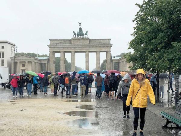Pariser Hafenplatz. Touristen im Dauerregen vorm Brandenburger Tor.