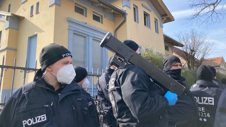 Ein Polizist steht vor dem beschlagnahmten Haus des Remmo-Clans mit einem Tür-Rammen bereit.