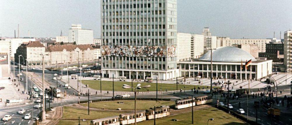 Berlin-Mitte, 1965, der Alexanderplatz vor der Umgestaltung. Die Autos rollen hier an der Konferenzhalle und vor dem Haus des Lehrers im Kreis; links ist sogar noch der Alt-Bau-Bestand an der Karl-Marx-Allee zu sehen.