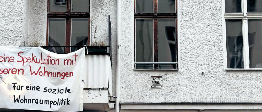 Ein Transparent gegen Wohnungsspekulationen hängt an einer Fassade eines Mietshauses in Berlin.