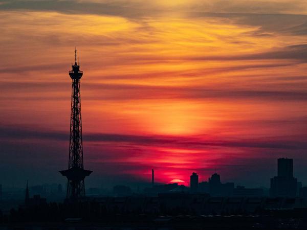 Die Sonne geht über dem Potsdamer Platz auf, links ist der Funkturm zu sehen.