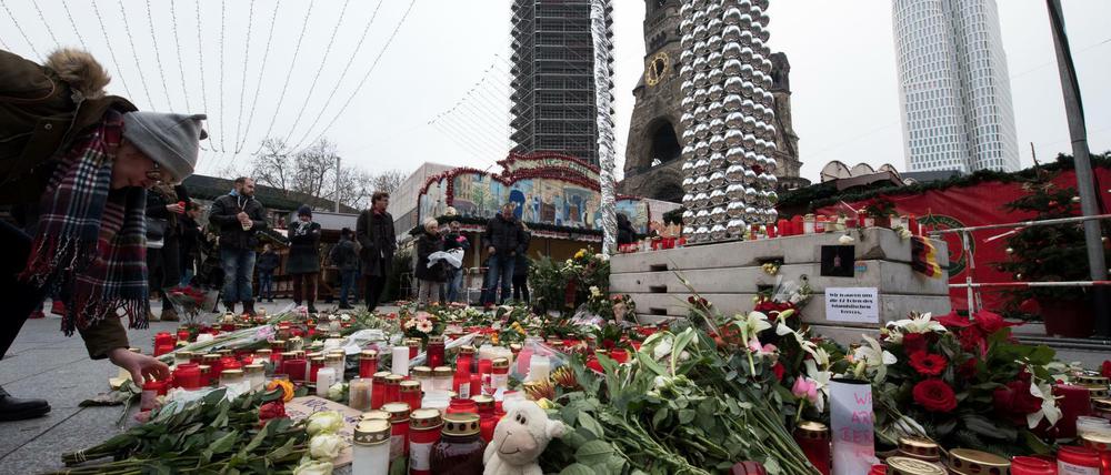 Trauernde legen am 21.12.2016 am Anschlagsort auf dem Weihnachtsmarkt am Breitscheidplatz in Berlin Blumen nieder und zünden Kerzen an. Bei dem Anschlag mit einem Lastwagen auf den Weihnachtsmarkt an der Gedächtniskirche am Montagabend (19.12.2016) in Berlin wurden zwölf Menschen getötet, mehr als 50 weitere Personen wurden zum Teil schwer verletzt. Foto: Bernd von Jutrczenka/dpa +++(c) dpa - Bildfunk+++
