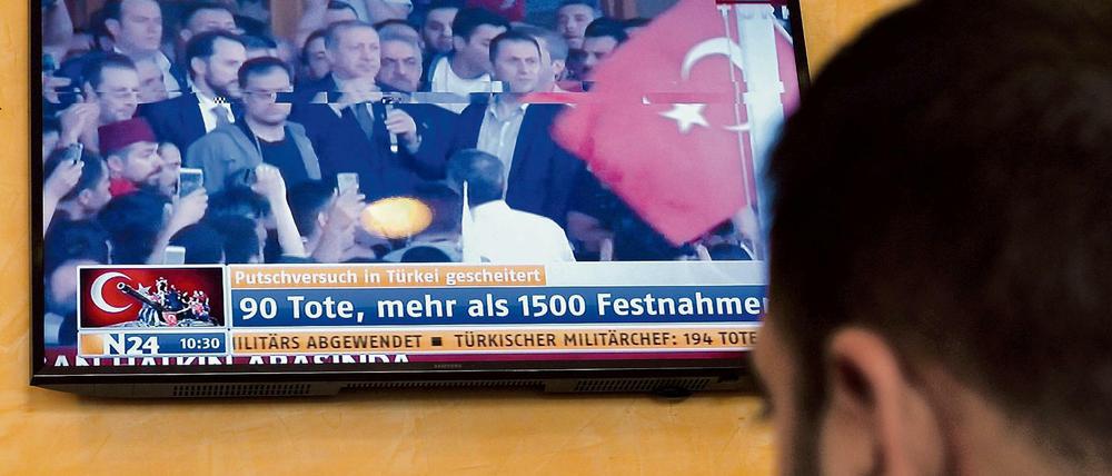 Ein türkischer Imbiss-Verkäufer schaut in Berlin im TV-Berichte aus der Türkei über den Putsch-Versuch. 
