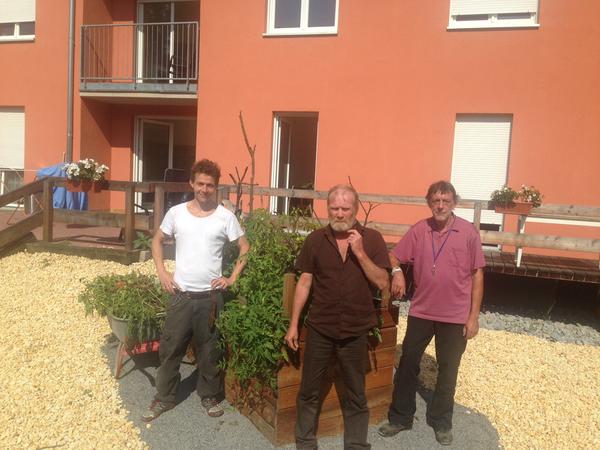 Fertig: Sozialarbeiter Sebastian Stein und die Bewohner Ingo Kommol und Werner Ulfert vor dem gemachten Hochbeet im Haus Hebron. 