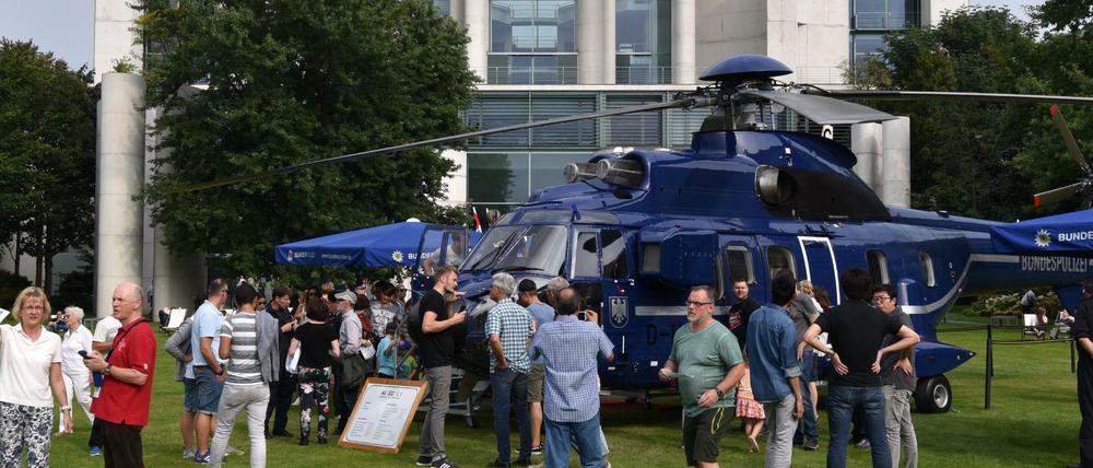 Besucher schauen sich im Hof des Bundeskanzleramtes in Berlin einen Hubschrauber der Bundespolizei an.