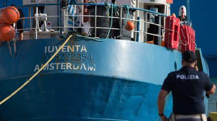 Ein italienischer Polizist steht am Hafenkai, als das Rettungsschiff „Iuventa“ der Berliner NGO „Jugend Rettet“ einläuft.