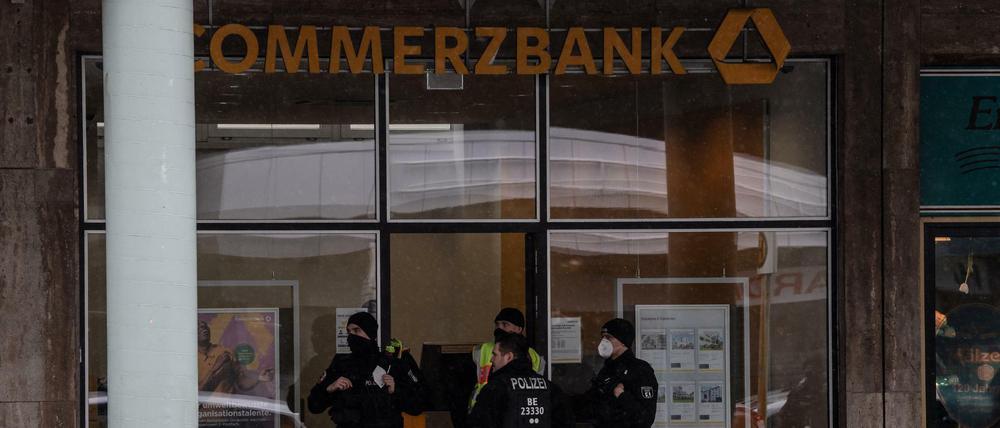 Polizisten stehen am Eingang einer Bankfiliale an der Blissestraße in Wilmersdorf. 