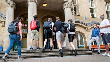 Schüler betreten am ersten Tag nach den Sommerferien den Eingang zum Rheingau Gymnasium in Berlin. In Brandenburg starten am Montag wieder alle Schüler im Präsenzunterricht.