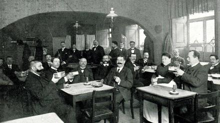 Altberliner Art. Berliner Weiße wird 1903 aus flachen Trinkgefäßen mit einem Umfang von Suppenschüsseln getrunken. Die Gäste der Weißbierstube haben mit dem Biergenuss alle Hände voll zu tun.