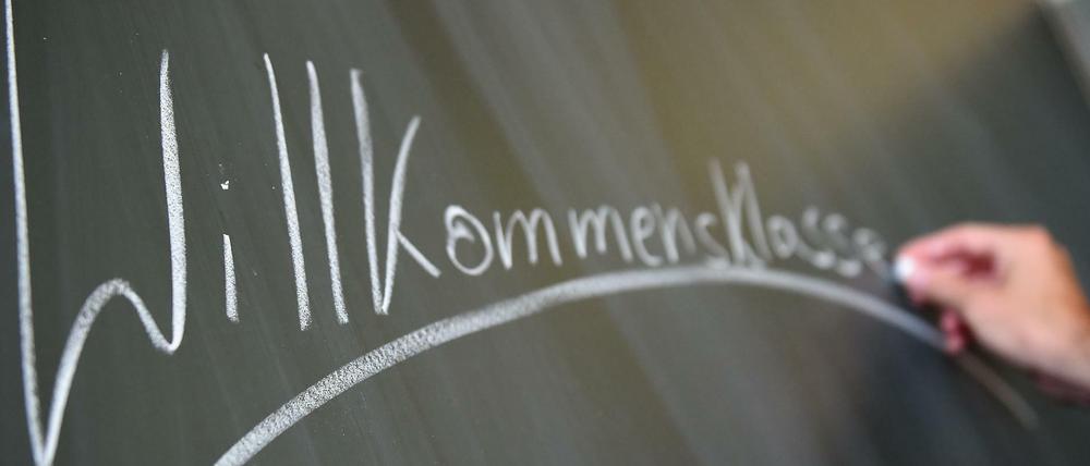 Der Lehrer Florian Schempp schreibt am 31.08.2015 an der Friedenauer Gemeinschaftsschule/1. Gemeinschaftsschule Schöneberg in Berlin das Wort "Willkommensklasse" an die Tafel. Foto: Britta Pedersen/dpa +++(c) dpa - Bildfunk+++