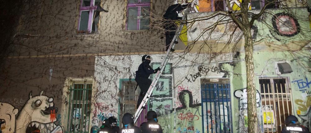 Polizisten steigen über Leitern in das Haus in der Rigaer Straße 94 ein.