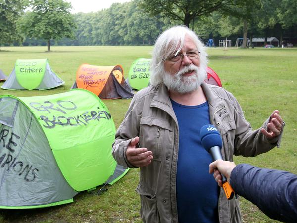 Robert Jarowoy von der Partei Die Linke spricht im Volkspark Altona in Hamburg mit Journalisten während einer Protestveranstaltung zu den G20-Protestcamps, bei der Zelte aufgestellt wurden.