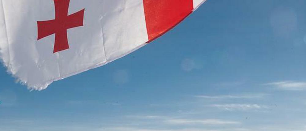 Gipfelkreuz. Die georgische Flagge dient als Sonnenschutz.