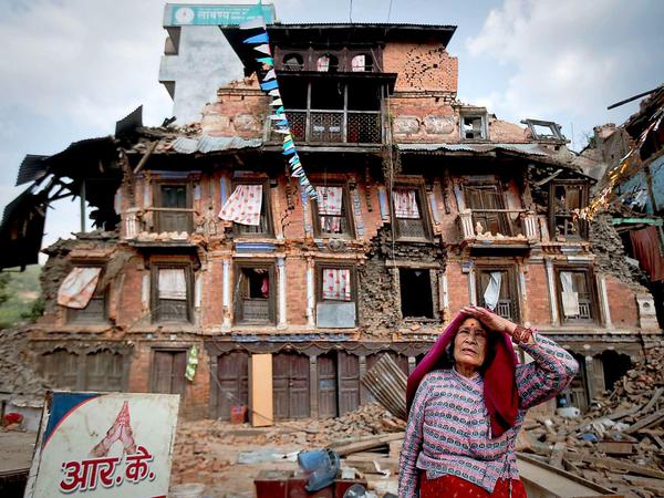 Eine Frau vor einem zerstörten Haus in Kathmandu.