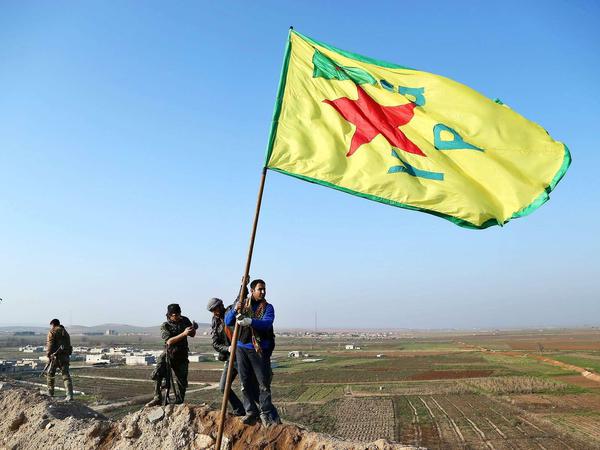 Kurden der linken YPG-Miliz hissen in Kobane, Syrien, am 26 January 2015 ihre Fahne: Monatelang haben sie gegen den IS gekämpft.