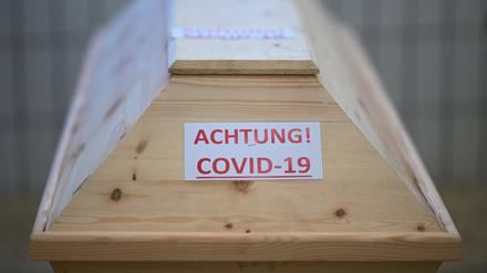 Ein Sarg mit der Aufschrift „Achtung! Covid-19“ steht in einem Raum im Krematorium, bevor der Sarg eingeäschert wird.
