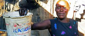 Eine Frau in Kenia bereitet eine Wanne mit Bier zum Baden gegen Masern vor. 