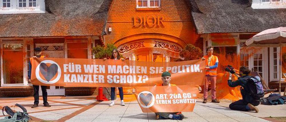 Klimaaktivisten haben zwei Luxusgeschäfte in dem Sylter Nobelort Kampen mit oranger Farbe besprüht.