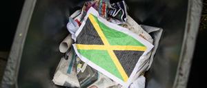 Ein zerknittertes Blatt Papier mit einer aufgedruckten Jamaika-Fahne im Müll (gestellte Szene)