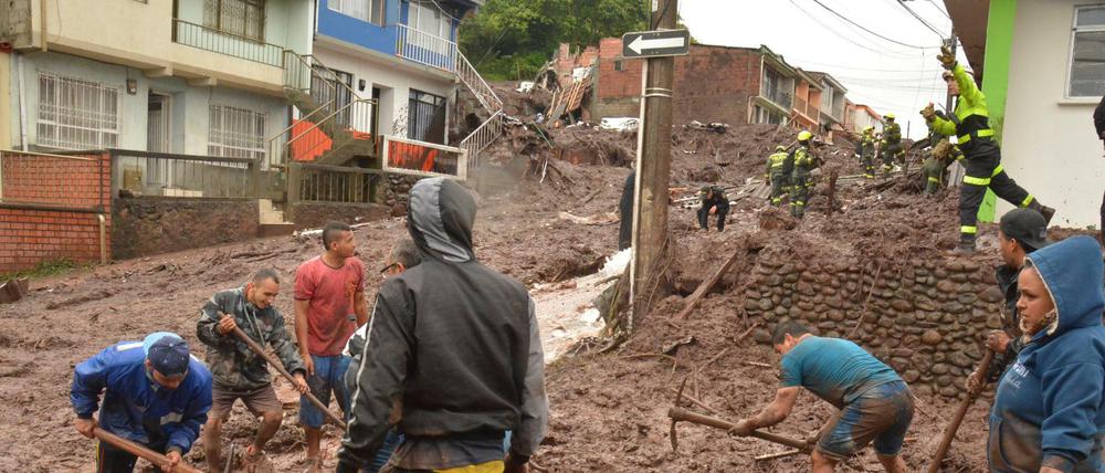 Bewohner der Stadt Manizales, im Westen Kolumbiens, helfen am Mittwoch bei den Räumungsarbeiten nach dem Erdrutsch, der in der Nacht acht Tote hinterließ. Um die 20 Menschen werden noch vermisst.