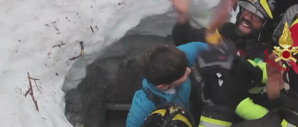 Die Rettungskräfte holen einen Jugendlichen aus dem von einer Lawine verschütteten Hotel Rigopiano. 