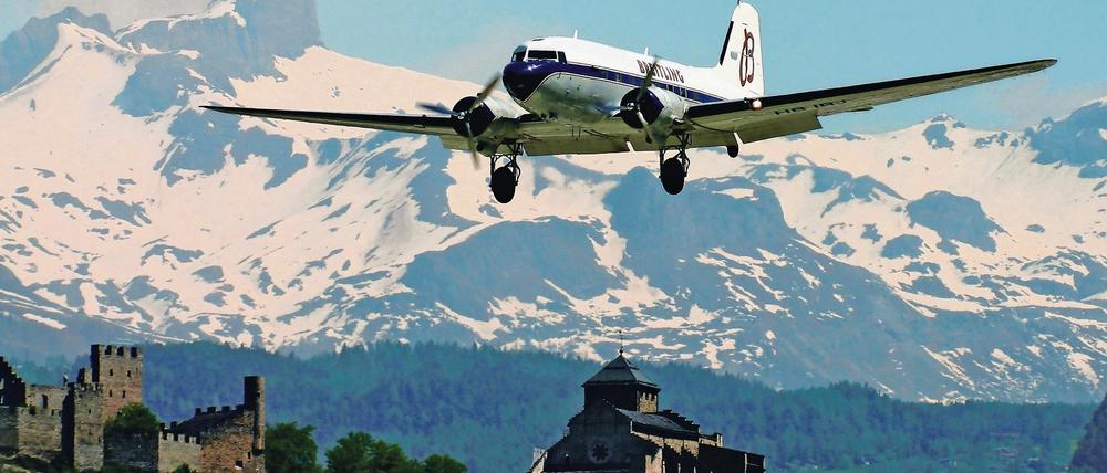 Die Genfer DC-3 beim Landeanflug in Sion (Wallis). Im Hintergrund sind die Burgen Tourbillon (links) und Valère zu sehen.
