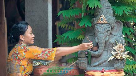 Gläubige Gastgeberin: Ida Ayu Putri, die in ihrem Haus Touristen aufnimmt, opfert dem Elefantengott Ganesha Räucherstäbchen. 
