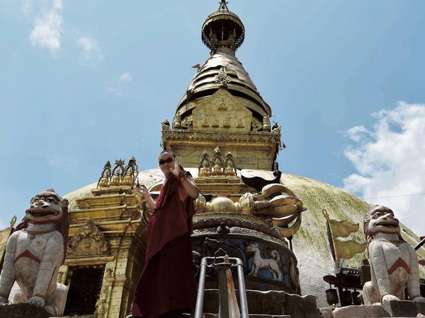 Wie so oft in Nepal sind im Tempelkomplex Swayambhunath bei Kathmandu buddhistische und hinduistische Elemente verschränkt: Oben die buddhistische goldene Stupa, unten zwei hinduistische Löwen, traditionell Reittiere von Göttinnen.
