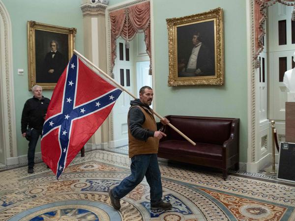 Ein Anhänger Donald Trumps läuft am 6. Januar 2021 mit einer Konföderierten-Flagge durch das Kapitol in Washington.