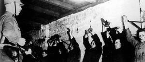 Zu Hilfspolizisten ernannte SA-Männer nehmen nach der Machtübernahme durch Adolf Hitler am 30. Januar 1933 Kommunisten fest.