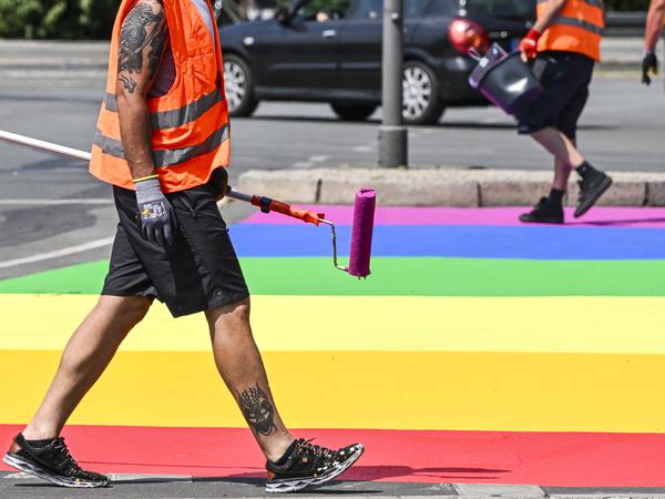 Mitarbeiter von „Kulturprojekte Berlin“ bemalen einen Straßenabschnitt am Großen Stern anlässlich des CSD in Regenbogenfarben an.