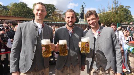Manuel Neuer, Harry Kane und Thomas Müller vom FC Bayern München vor dem Käferzelt auf dem Oktoberfest.
