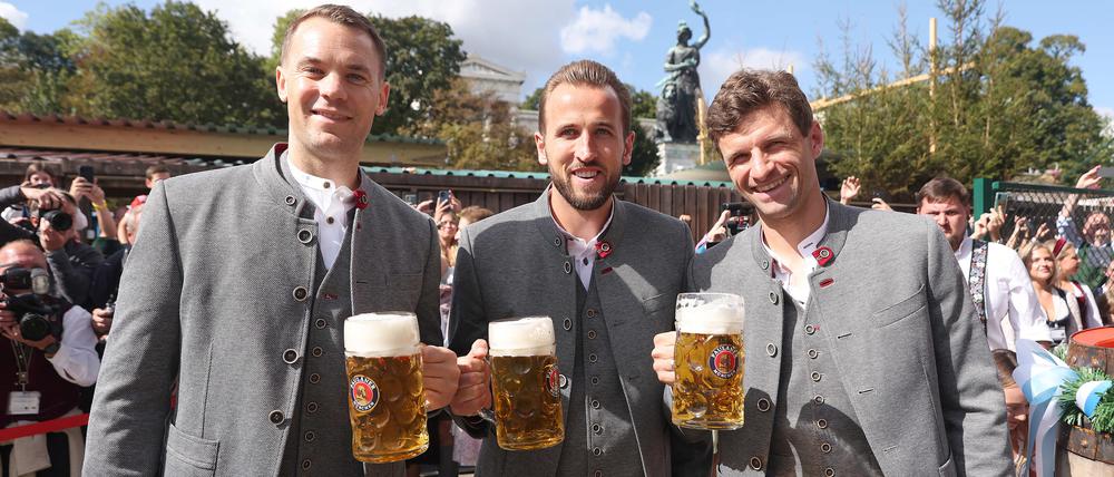 Manuel Neuer, Harry Kane und Thomas Müller vom FC Bayern München vor dem Käferzelt auf dem Oktoberfest.
