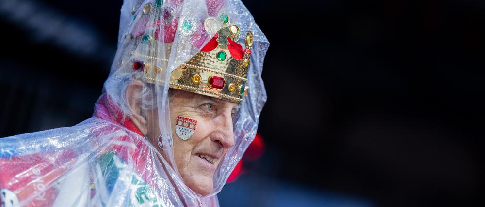 Ganz im Gegensatz zu diesem königlichen Karnevalisten. Ein Regencape schützt Haupt und Krone.