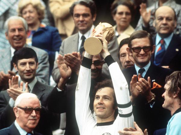 Der glückliche Kapitän Franz Beckenbauer hebt an der Seite von Torhüter Sepp Maier und dem englischen FIFA-Präsidenten Stanley Rous am 07.07.1974 im Münchner Olympiastadion nach dem Endspiel der Fußball-WM den eroberten WM-Pokal triumphierend hoch. 