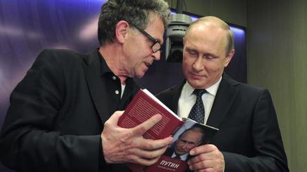 Hubert Seipel und der russische Präsident Wladimir Putin schauen gemeinsam in eines von Seipels Büchern.