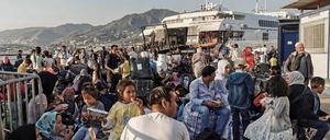 Migranten warten am Hafen von Lesbos, Griechenland, auf den Transport auf das Festland.